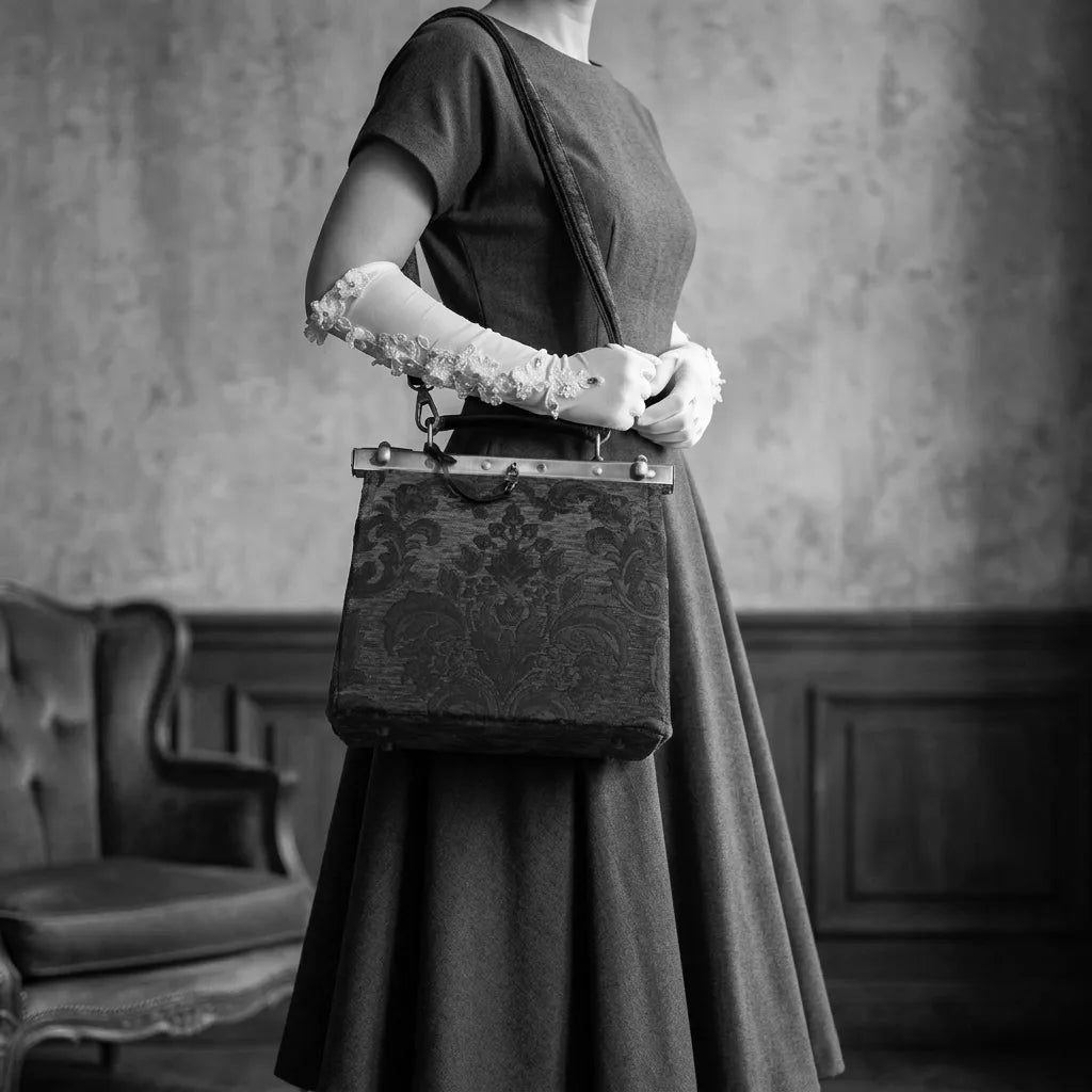 Person in a vintage-style dress holding a matching cecile purse in a room with classic decor.