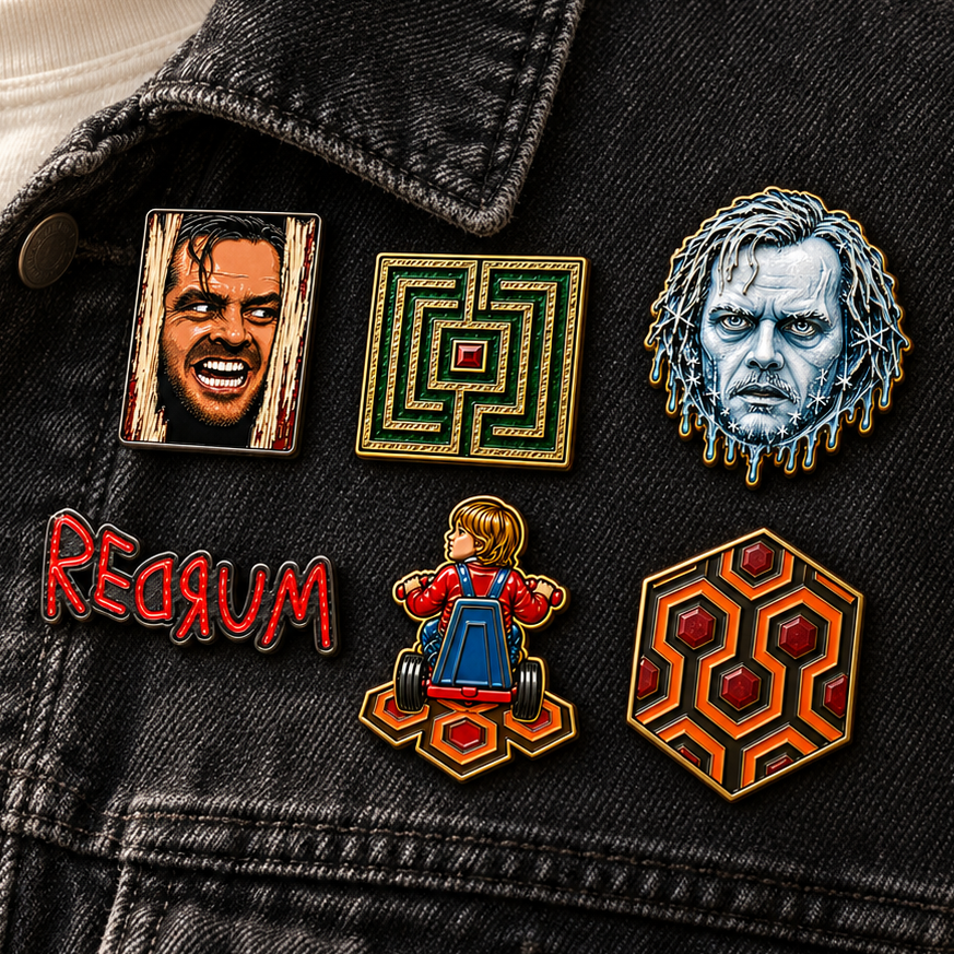 6 enamel lapel pins displayed on a black denim jacket. The pins feature horror-themed designs from Movie "The Shining", from MCW CARPETBAGS.