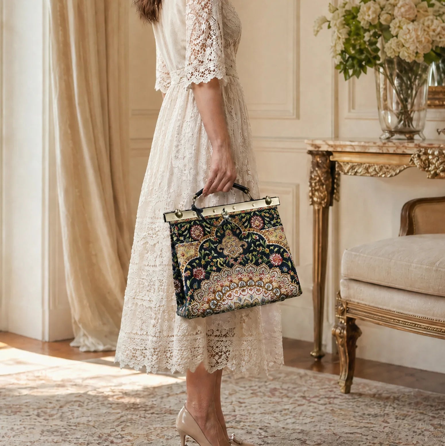Woman in a lace dress holding an oriental navy cecile carpet purse gladstone bag by hand.