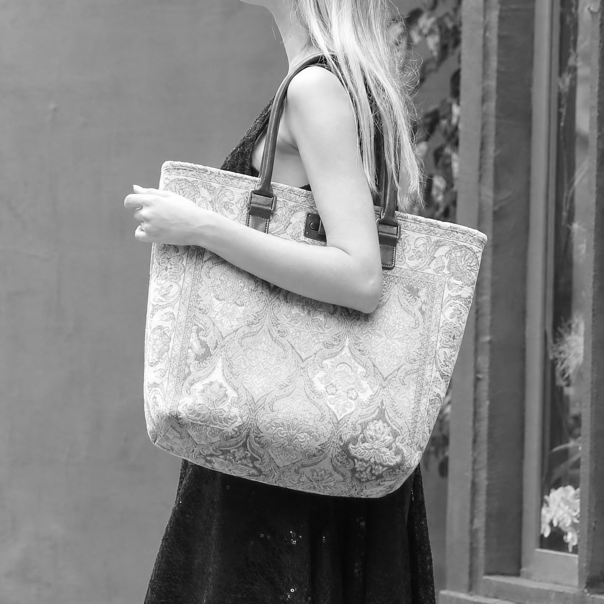 Person holding a patterned tote bag against a neutral background
