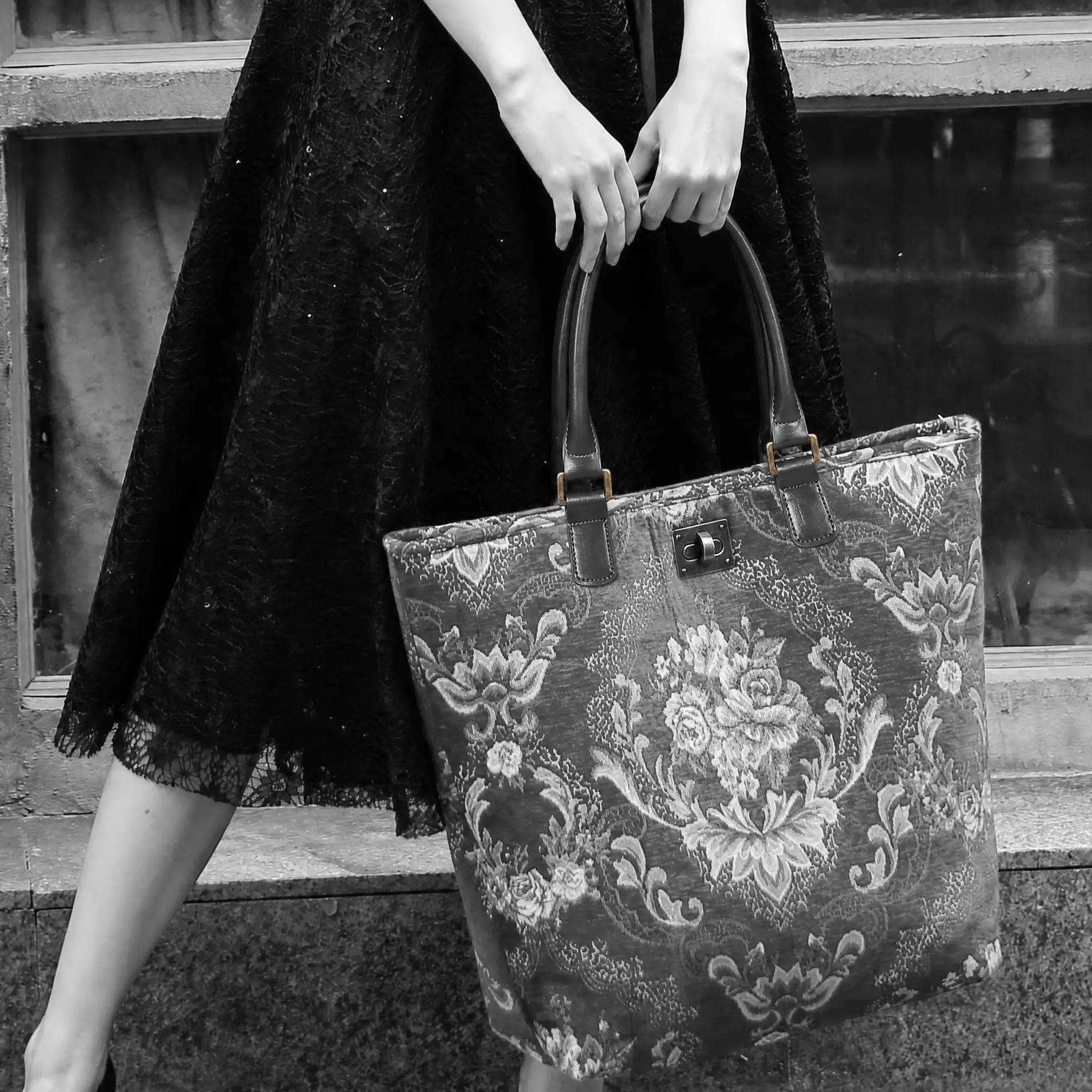 Person holding a floral-patterned shopper in a black and white setting