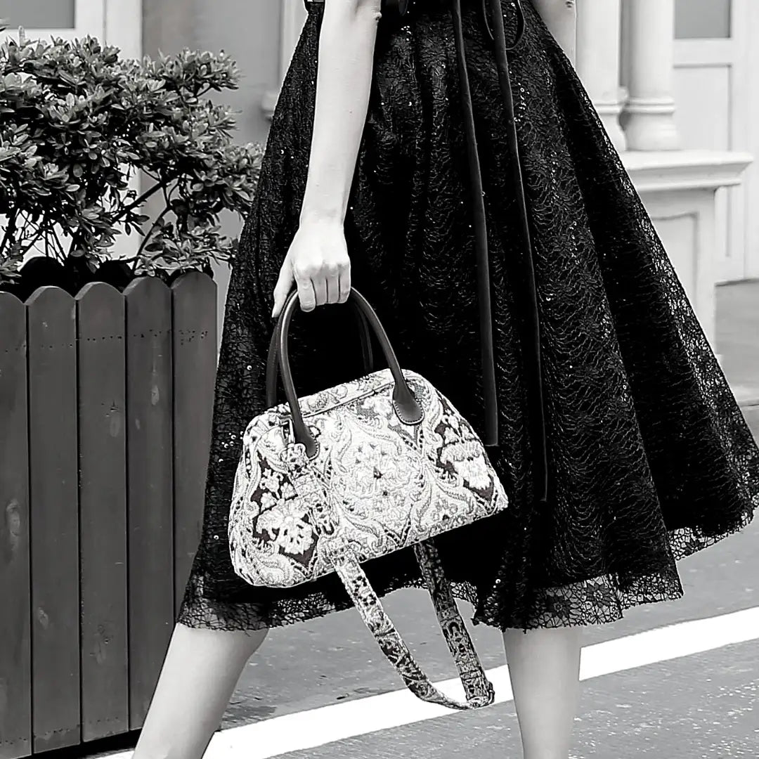 Victorian-inspired chenille carpet handbag with leather handles and detachable shoulder strap.