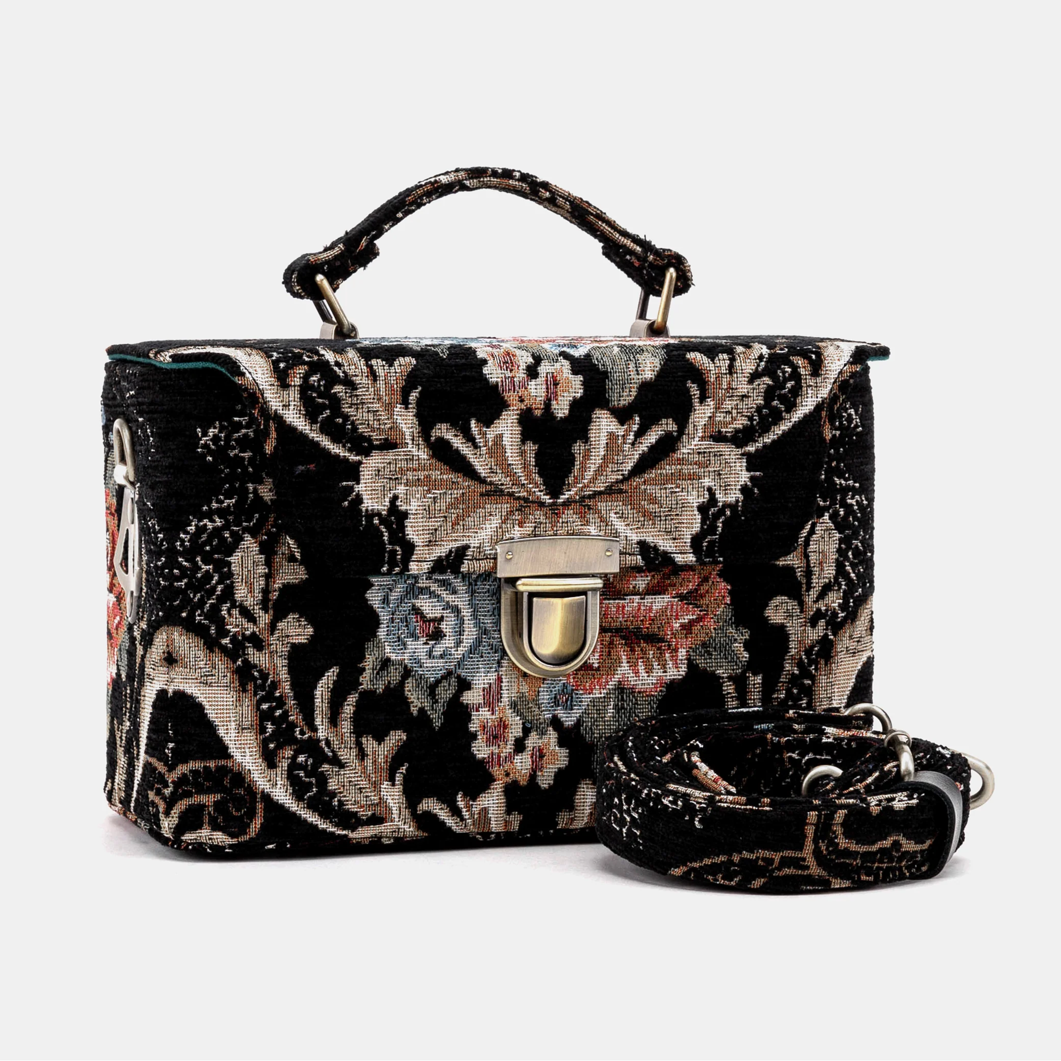 Floral embroidered handbag with a matching strap on a light gray background
